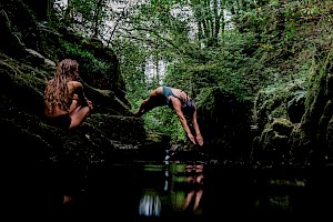 This colour photo shows models diving into lake for finisterre brand  by James Bowden, UK  photographer, represented by Horton-Stephens photographer’s agents specialises in natural and authentic  lifestyle outdoors nature photographic images.
