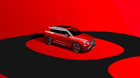 Sleek Bentley car shot on a red and black circular graphic background in the studio by photographer Wilson Hennessy represented by top London agents Horton-Stephens.