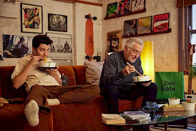 Robert De Niro and Asa Butterfield slurp noodles on a sofa shot by photographer Marco Mori represented by Horton-Stephens photographers agents for Uber One